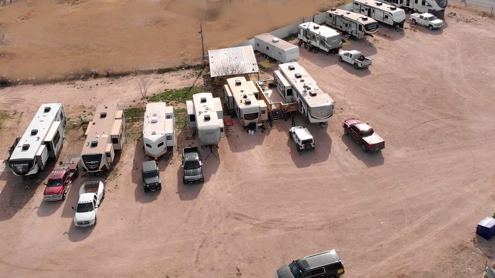 An aerial view of a wide lawn where many RV and cars are parked.